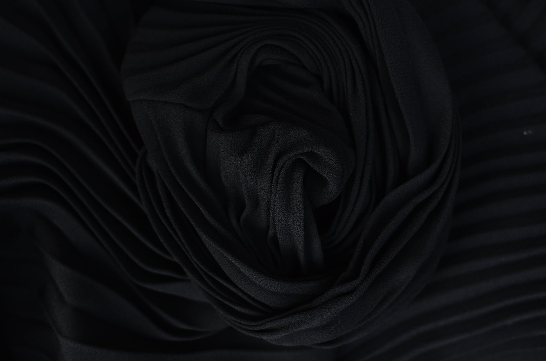 textured backdrop of soft crumpled textile in darkness